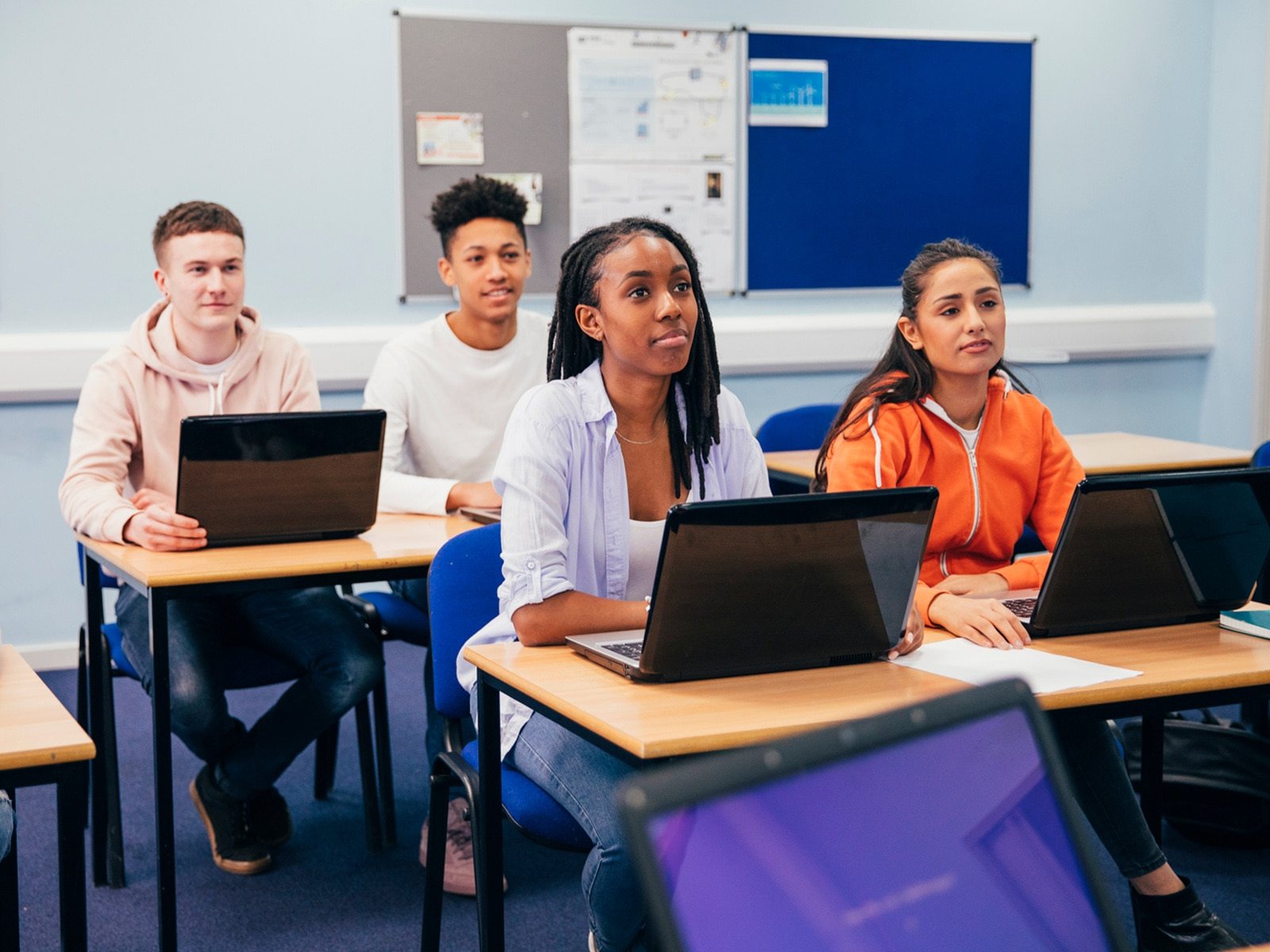 A group of students listen to their tutor.